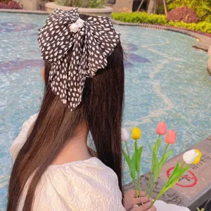 Vue détaillée d'une barrette à nœud en mousseline plissée avec perles pour filles
