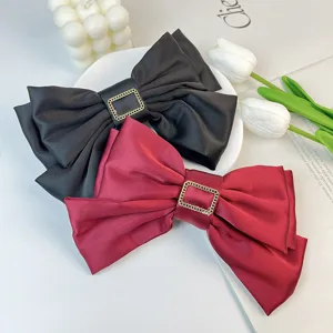 Large red and black three-layer satin bow hair clips featuring a gold square buckle