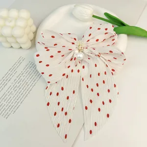 Pince à cheveux élégante en mousseline plissée blanche à pois rouges et perles de nacre.