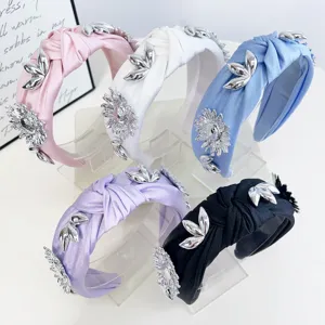 Detailed view of assorted colors knotted headbands with 3D metallic flower decorations.