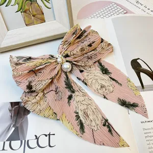 Détail d'un nœud papillon en mousseline fleurie rose avec perles et plis élégants