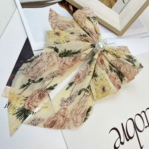 Vue détaillée d'une barrette nœud en mousseline fleurie avec un accent perlé élégant