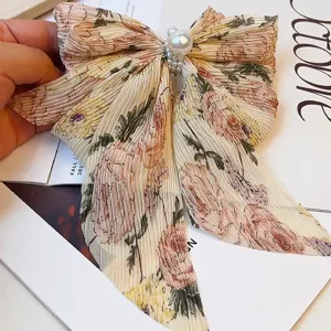 Vue détaillée d'une barrette à nœud élégante en mousseline fleurie avec perles blanches