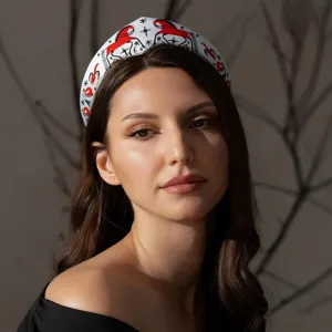 Detailansicht eines russischen Retro-Stirnbands mit roter Sonnenvogel-Stickerei.