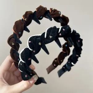 Detailansicht eleganter Samt-Stachelstirnbänder mit bunten Strasssteinen.