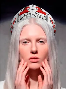 Nahaufnahme eines weißen Kokoschnik-Stirnbands mit roter Stickerei im russischen Stil.
