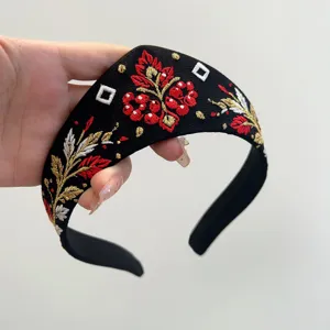 Detailaufnahme der russischen Vintage-Sonnenvogel-Stickerei auf einem schwarzen Stirnband