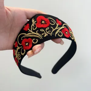 Nahaufnahme der roten Mohn- und Goldstickerei auf einem schwarzen Stirnband