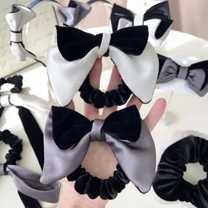 Primo piano di elastici per capelli con fiocchi in velluto nero e raso grigio a mano