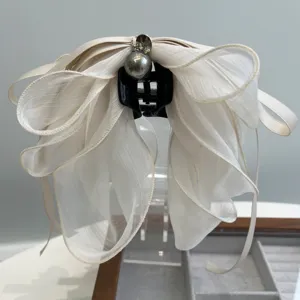 Detalle de pinza para el pelo con lazo de malla elegante y perla oscura