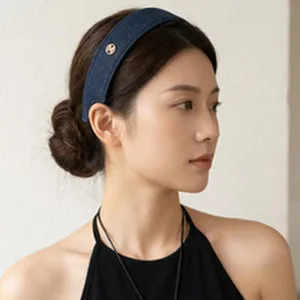 Side view of elegant blue denim wide headband on model with gold button detail
