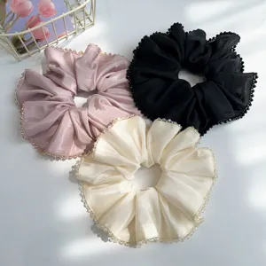 Detailed macro shot of satin scrunchies with elegant crystal bead-trimmed edges