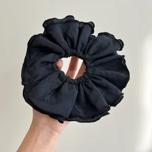 Primer plano de un coletero negro de gran tamaño con cuatro capas de textura plisada
