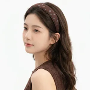 Close-up view of a vintage wide brown floral headband worn by an Asian model