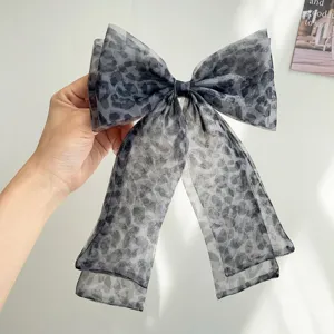 Vue détaillée d'un nœud papillon romantique en résille imprimé léopard gris avec rubans