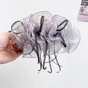 Detailed close-up of a lavender silk gauze bow hair claw clip with black ribbon accents.