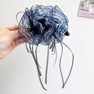 Close-up of elegant blue striped organza hair flower clip with long black ribbons