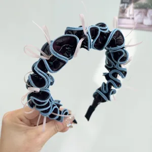 Gros plan d'un élégant serre-tête en tulle à volants avec dentelle bleue et rubans roses.