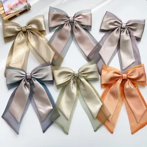 Detail view of iridescent organza bow hair clips with long ribbons in six colors