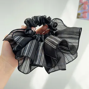 Close-up of a black and white striped oversized ruffled organza hair scrunchie.