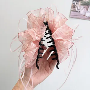 Detail view showing the texture of an elegant pink ruffled ribbon banana hair clip