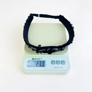Weight measurement of black sequined headband crown showing 27.3 grams on scale