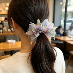 Vista dettagliata di un grande elastico per capelli a fiori iridati su una coda di cavallo
