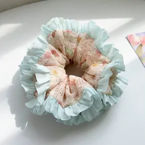 Close-up of sweet floral printed scrunchie with light green pleated ruffle edges