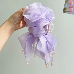 Detailaufnahme einer lavendelfarbenen Netzhairclip mit Perlenanhängern