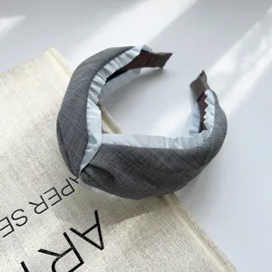 Detailansicht eines grauen Haarreifens mit hellblauen plissierten Rüschenkanten.