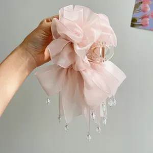 Nahaufnahme der zarten rosa Netzschichten und Kristallperlen dieser eleganten Haarklammer