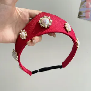 Nahaufnahme eines roten Vintage-Haarreifens mit kunstvollen Perlenblumen-Dekoren