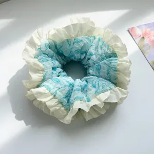 Elegant blue floral mesh hair scrunchie featuring white pleated ruffle edge details