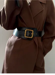 Detailaufnahme eines breiten schwarzen Taillengürtels mit vintage goldener Schnalle.