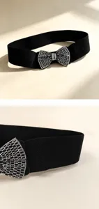 Close-up detail of black elastic waist belt with sparkling rhinestone bow buckle for dress.
