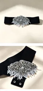 Detailed view of women's black elastic waist belt featuring ornate rhinestone pearl buckle.
