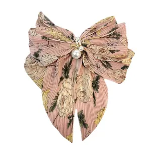 Pince à cheveux noeud en mousseline fleurie plissée avec perles sur fond blanc