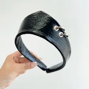 Vista dettagliata della fascia larga in pelle nera con due anelli d'argento metallici