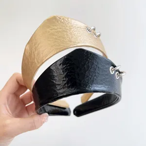 Dettaglio di cerchietti vintage in pelle martellata con accenti di anelli d'argento in nero e oro