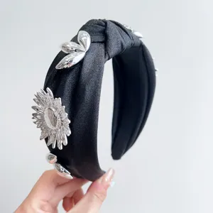 Elegant black knotted headband featuring 3D silver metallic flower and leaf decorations