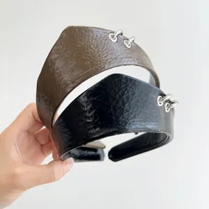 Dettaglio di cerchietti in pelle testurizzata con anelli in argento in nero e marrone
