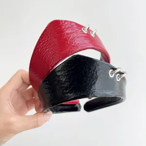 Dettaglio cerchietti in pelle stropicciata rossi e neri con anelli metallici argento.