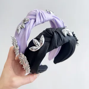 Detailed macro view showing silver metallic flower decorations on a knotted satin headband