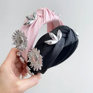 Detailed view of pink and black knotted headbands with silver metallic flower accents