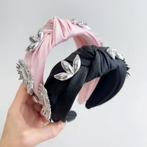 Detailed view of pink and black knotted headbands with silver floral metallic ornaments