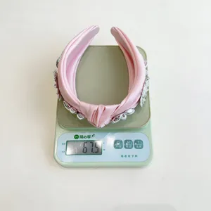 Pink knotted wide headband with 3D metal flower accents, weight shown at 67.5 grams