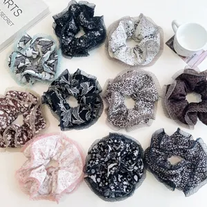 Close-up of assorted floral and leopard pattern scrunchies with pleated mesh edges