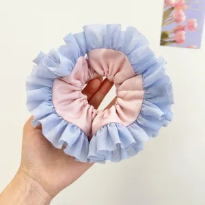 Primo piano di un elastico per capelli in pizzo plissettato rosa e blu stile ballet