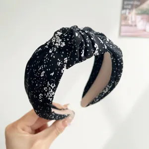 Detailed macro view of wide knotted headband with black and white ink floral print