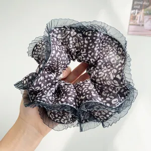 Close-up of a leopard print scrunchie with mesh ruffle trim